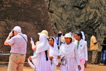 tourists taking photos and milling around rockformations on a trip