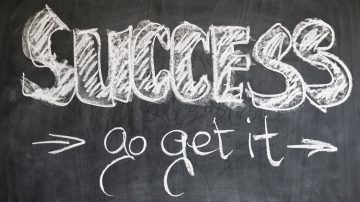 success go get it written in white chalk on blackboard