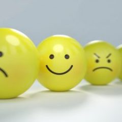 4 yellow rubber balls with face expressions written on them like happy sad mad and worried