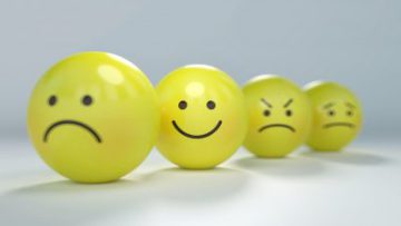 4 yellow rubber balls with face expressions written on them like happy sad mad and worried