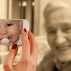 young hands holding a phone camera up to an elderly woman shows a baby face peering back instead