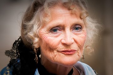 photo of pretty elderly woman with bright blue eyes and dangly gold earrings